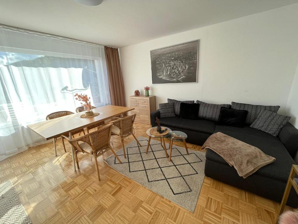 een woonkamer met een zwarte bank en een tafel bij Marburg 3 Zimmer Wohnung Wiesenweg in Marburg an der Lahn