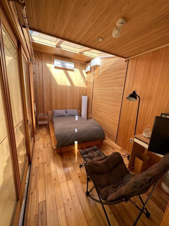 Habitación con 1 cama y 2 sillas. en Fuji Dome Glamping en Fujikawaguchiko
