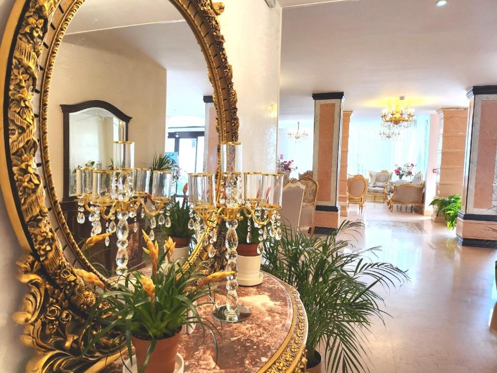 Habitación con espejo y mesa con plantas. en HOTEL ROYAL Paris Ivry, en Ivry-sur-Seine
