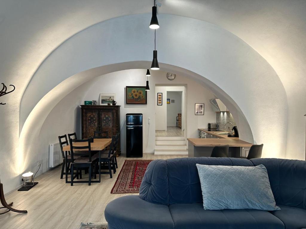 een woonkamer met een blauwe bank en een tafel bij exquisit home in historic vault in Gmunden