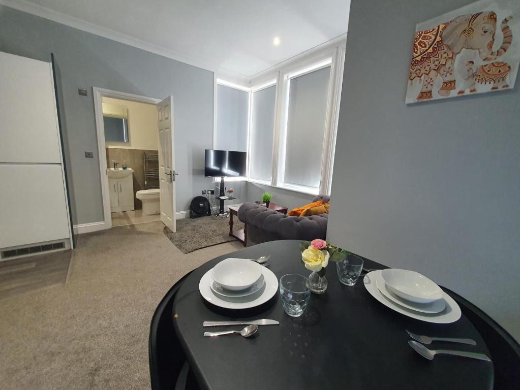een woonkamer met een tafel met borden erop bij Beautiful Maidstone Gem - Sleeps 2 in Kent