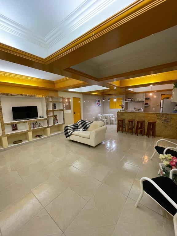 ein großes Wohnzimmer mit einem Sofa und einem TV in der Unterkunft claussporto in Porto De Galinhas