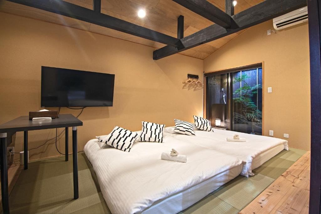 a bedroom with a large white bed with a flat screen tv at Kyoto - House - Vacation STAY 13904 in Kyoto
