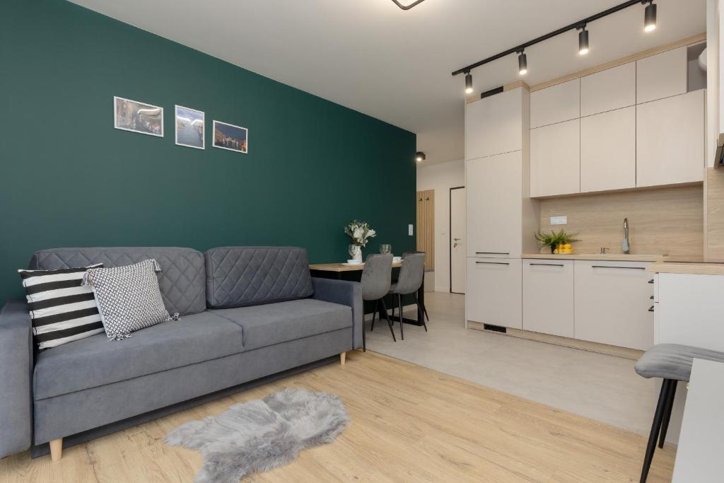 sala de estar con sofá gris y cocina en Goodnight Apartments Białołęka with 2 Bedrooms & Parking by Renters en Varsovia