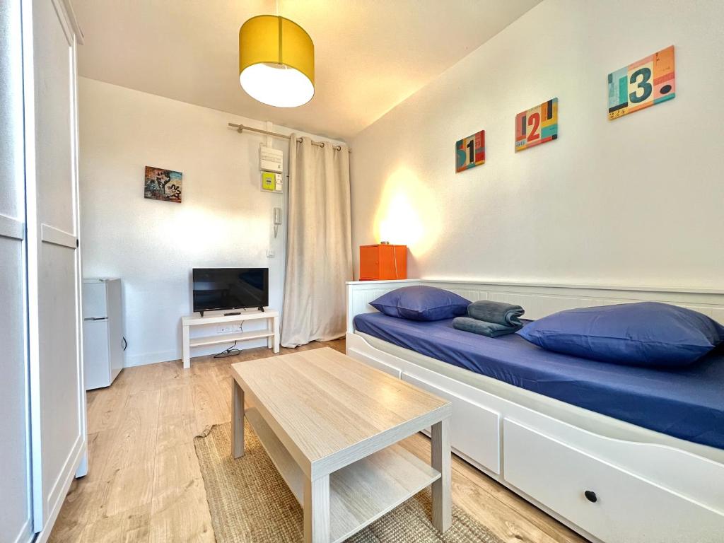 une petite pièce avec un lit et une table dans l'établissement Le Kansas ~ Studio à 5 min du centre ville ~ FIBRE, à Poitiers