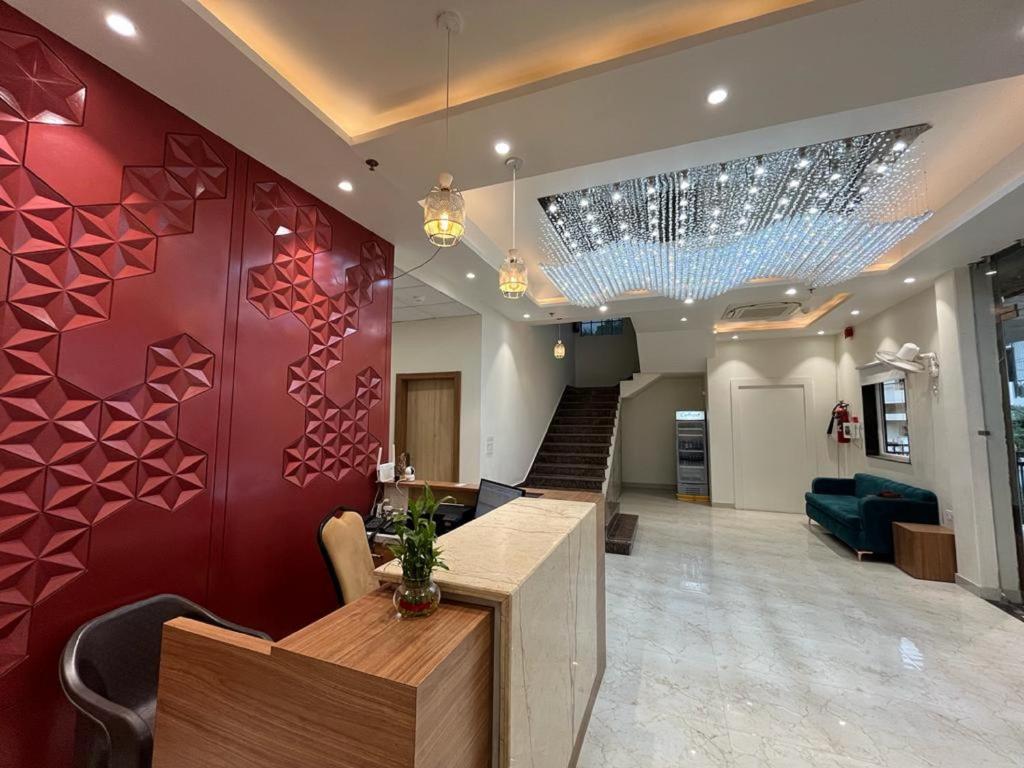 una sala de estar con paredes rojas y una escalera. en Hotel Satsang Grand, en Varanasi