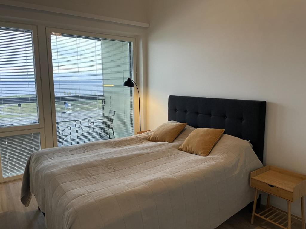 a bedroom with a large bed with a large window at Beautiful loft apartment with glazed balcony in Tampere