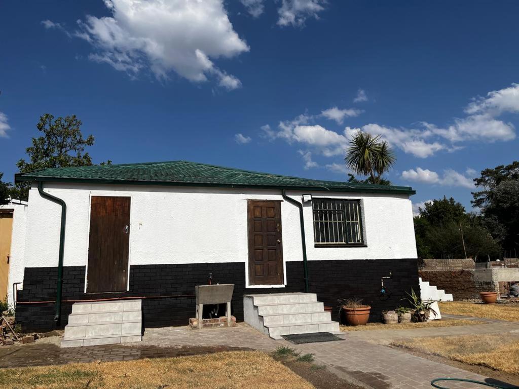 una casa in bianco e nero con una palma in cima di BDN Backpackers a Johannesburg