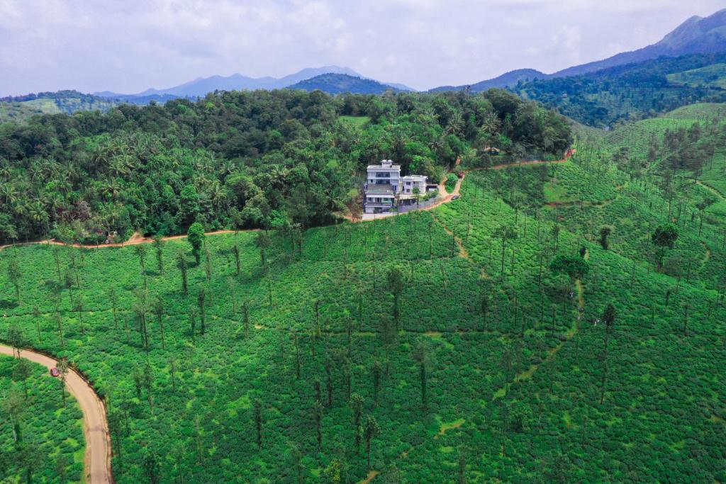 uma vista aérea de uma colina com uma casa sobre ela em Leaves Resort Vythiri Wayanad em Vythiri