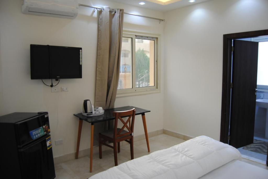 a bedroom with a desk and a tv and a bed at Villa 3 Studios in 6th Of October