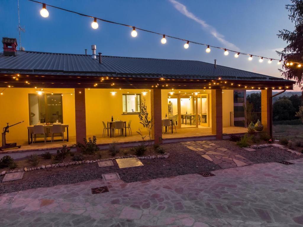 a yellow house with lights and a patio at Agriturismo Cà Vida in Ziano Piacentino