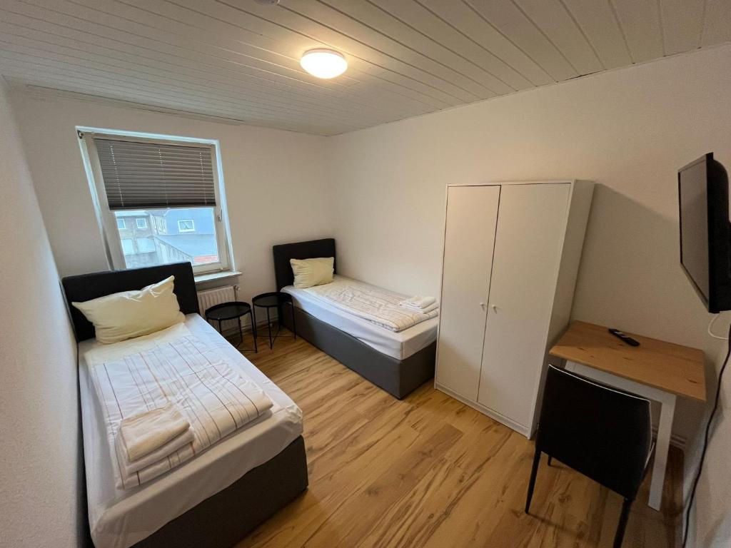Kleines Zimmer mit 2 Betten und einem Schrank in der Unterkunft Monteurwohnungen nähe Holsten Galerie in Neumünster