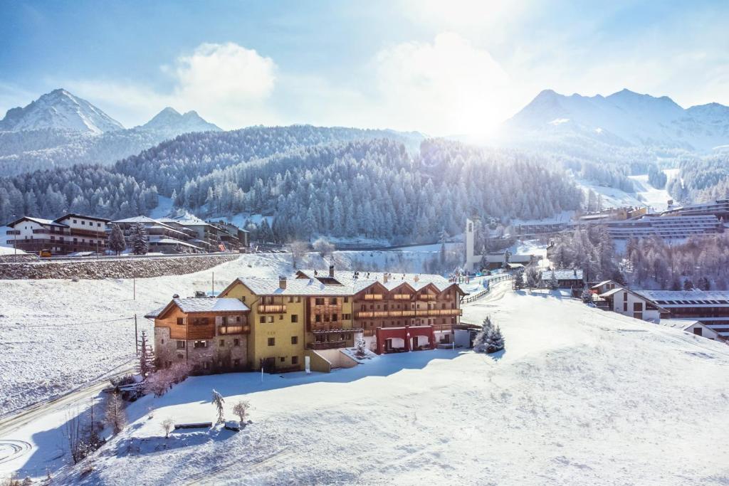 a town in the snow with mountains in the background at Hotel La Chance in Pila