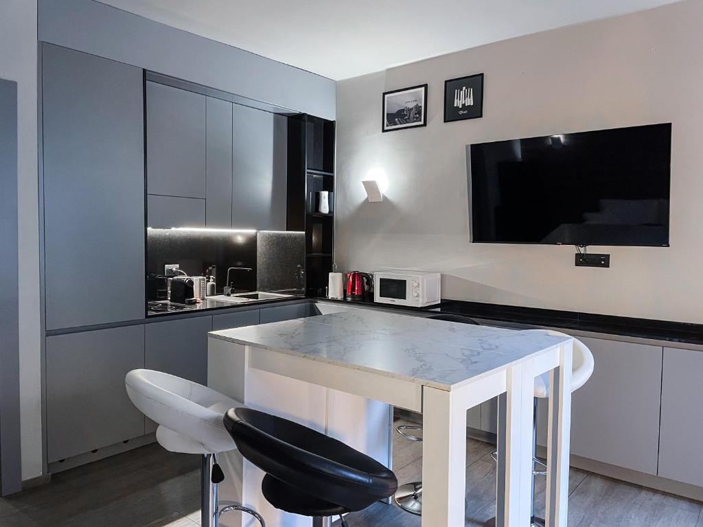 una cucina con tavolo, due sedie e una TV di Bubi House Moscova a Milano