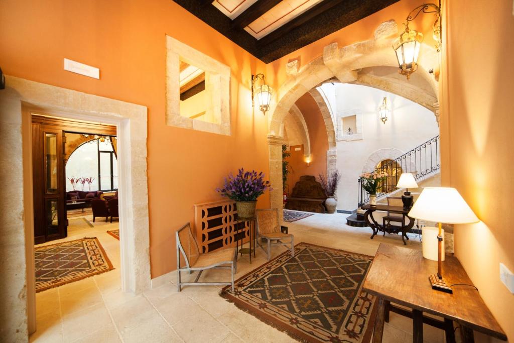 a living room with an archway and a dining room at Algilà Ortigia Charme Hotel in Siracusa