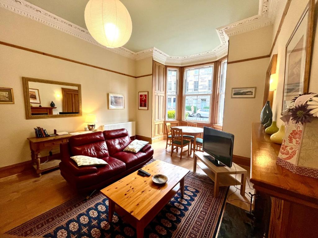a living room with a couch and a table at Beautiful Spacious Ground Floor Newington flat in Edinburgh