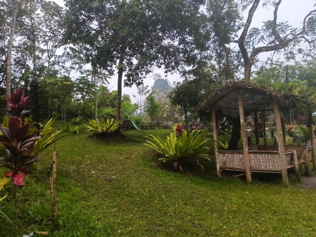 a bench in a garden with a gazebo at Tapian Ratu Camp in Bukittinggi
