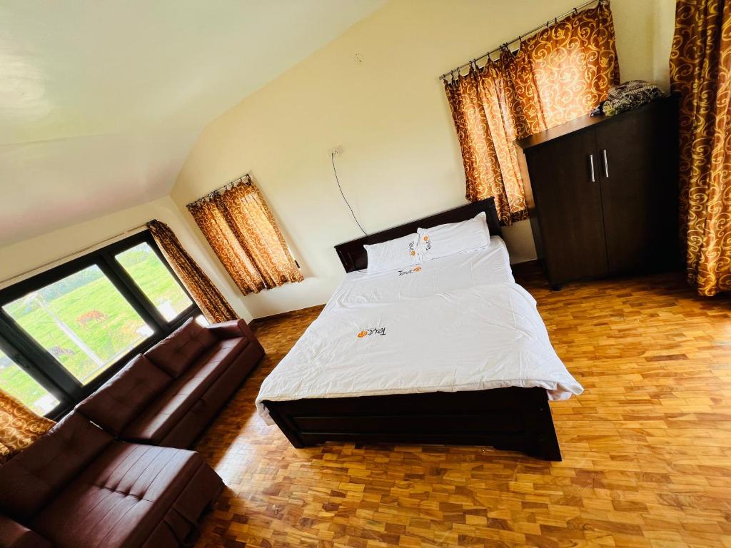 - une chambre avec un lit et un canapé en cuir dans l'établissement Teyt Castle, à Ooty