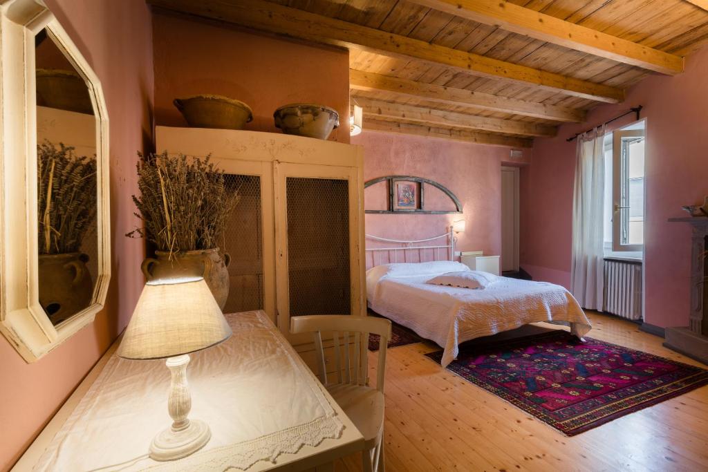 een slaapkamer met een bed en een tafel met een lamp bij B&B Corte del Mincio in Monzambano