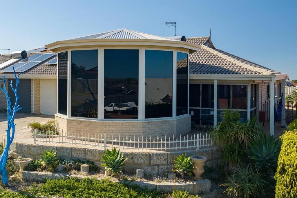 a house with a large glass window on it at Magnolia Sea Views in Mandurah