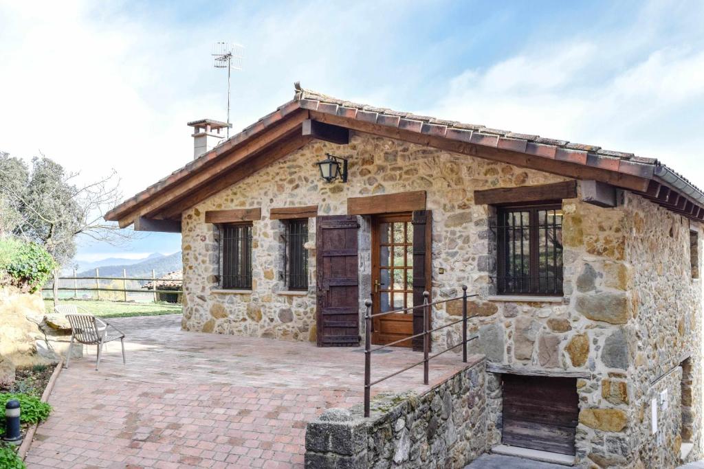 a stone house with a large patio at La Cabanya de la Rovira in Joanetes