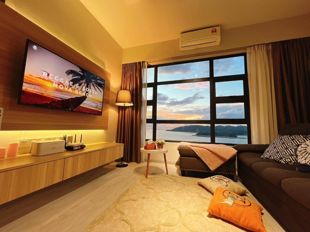 sala de estar con sofá y ventana grande en Mango House6-High floor I Biggest unit I SeaView I Waterfilte I Wifi-JQ en Kota Kinabalu