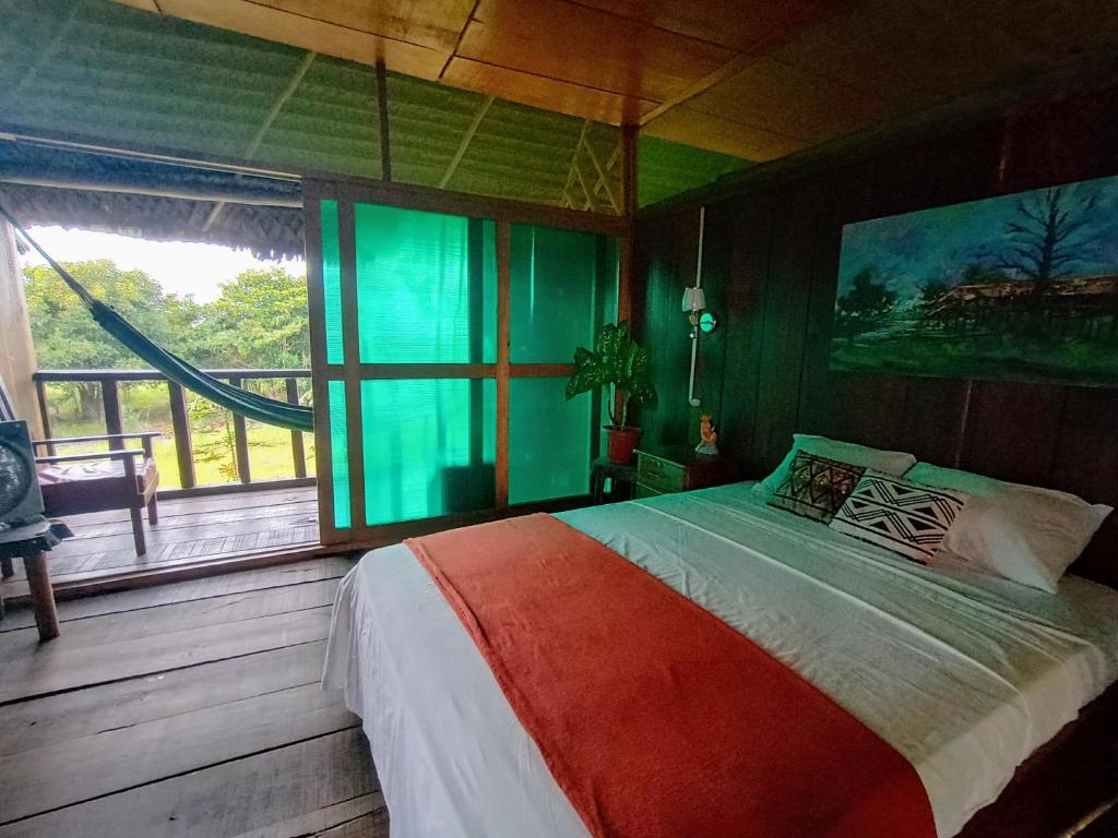 a bedroom with a bed and a large window at Casa Kukama Lodge in Iquitos