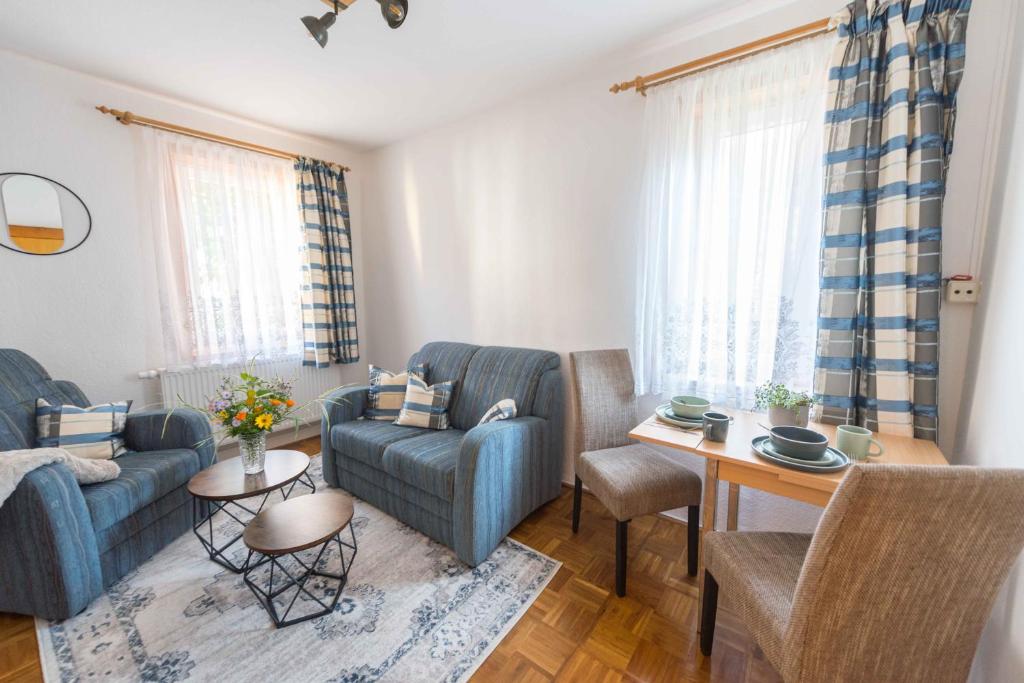 a living room with two blue chairs and a table at Im alten Kino in Fehrenbach