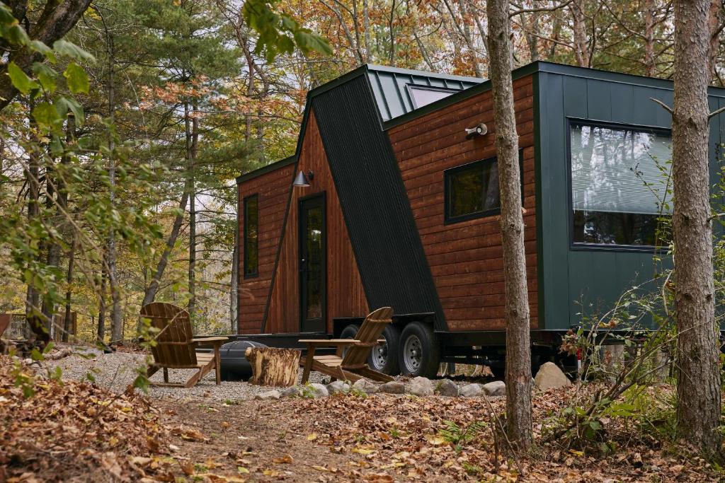 ein winziges Haus auf einem Wohnwagen im Wald in der Unterkunft Sowilo All-inclusive Resort in Greenwich
