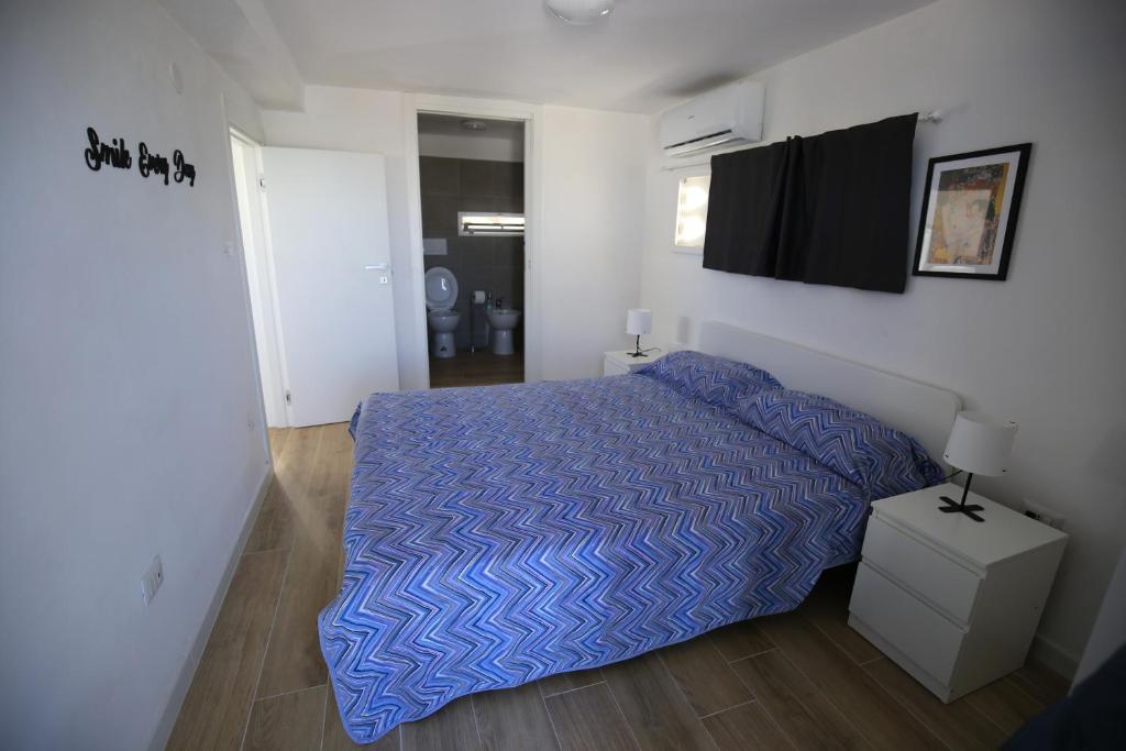 een slaapkamer met een bed met een blauw dekbed bij Mini appartamento sul mare in Molfetta