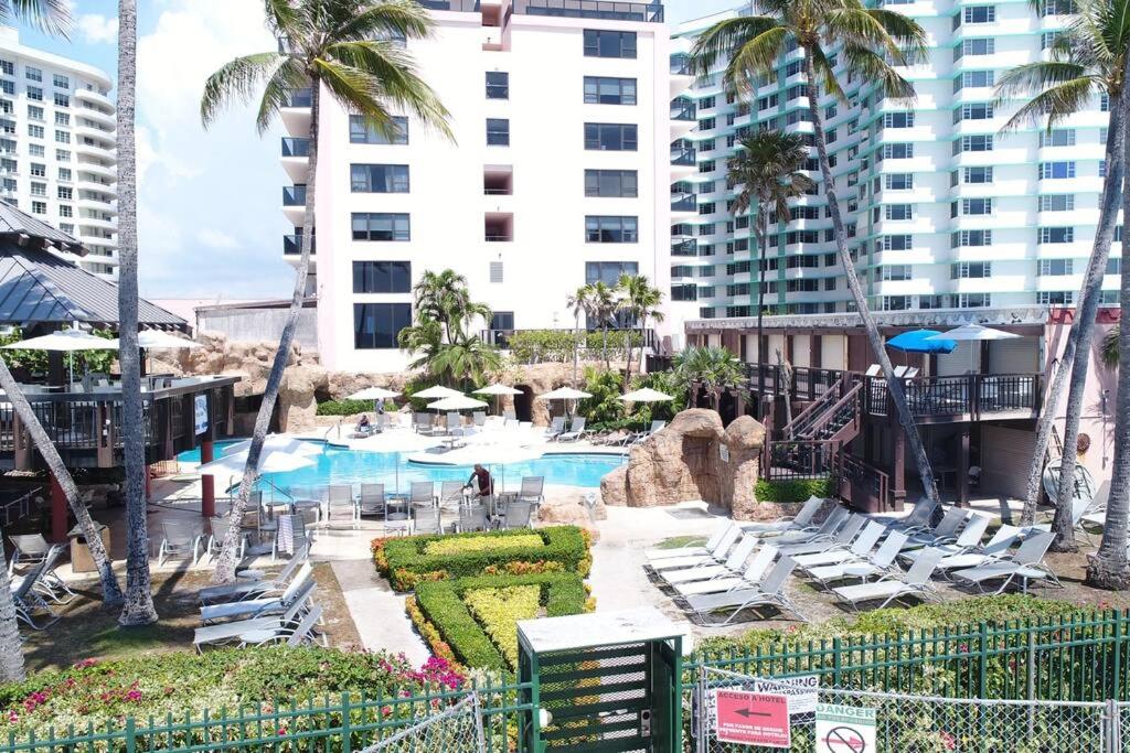 um resort com piscina e cadeiras e um edifício em 2 bedroom apartment w balcony & ocean view @ the beach 154 em Miami Beach