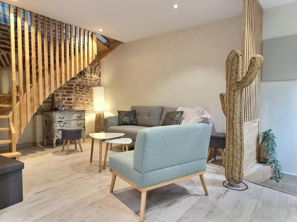 un salon avec un canapé et une chaise dans l'établissement La Muse d'Avril - Wifi - Hyper Centre, à Albi