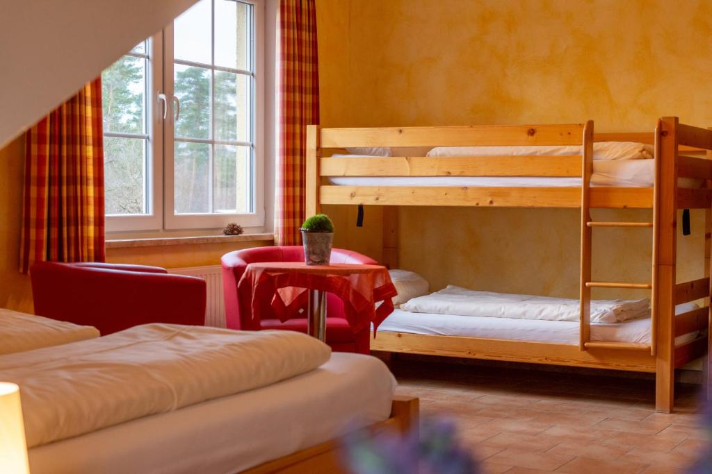 Zimmer mit 2 Etagenbetten und einem Tisch in der Unterkunft Vierbettzimmer 3 in Soltau