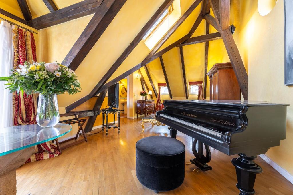 uma sala com um piano e um vaso de flores em Nosticova Apartments em Praga