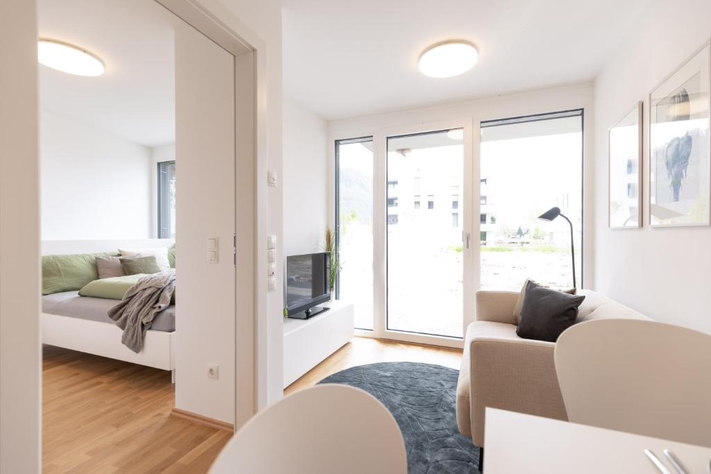 een witte woonkamer met een bank en een tv bij Smart Living Dornbirn in Dornbirn