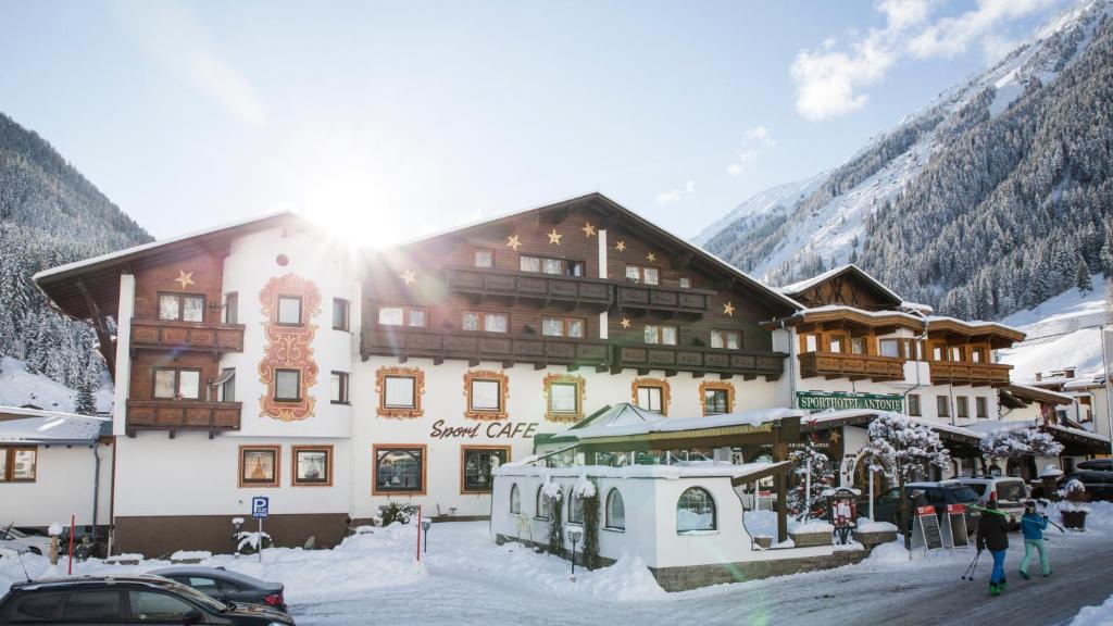 ein großes Gebäude im Schnee vor einem Berg in der Unterkunft Bergsporthotel Antonie in Gries im Sellrain