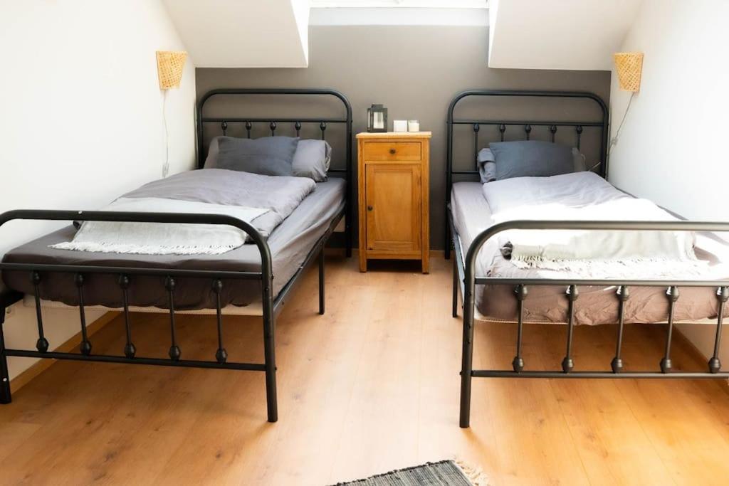 two twin beds in a room with a wooden floor at Schlaf-Scheune auf Islandpferdehof im Grünen in Steinau an der Straße