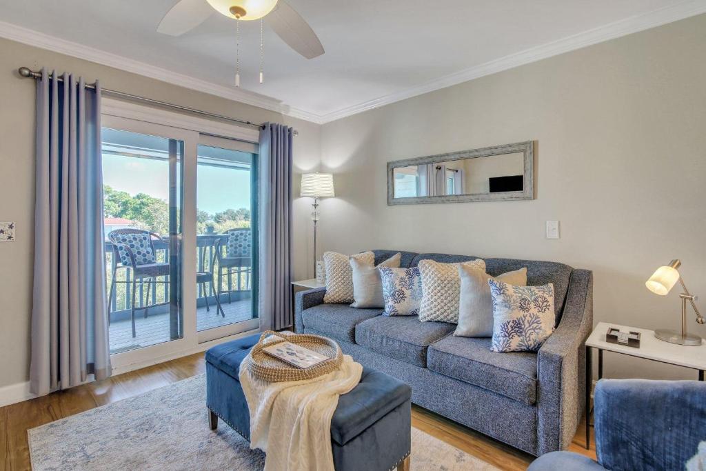 a living room with a couch and a balcony at Hamlet's Passion Beach in Tybee Island