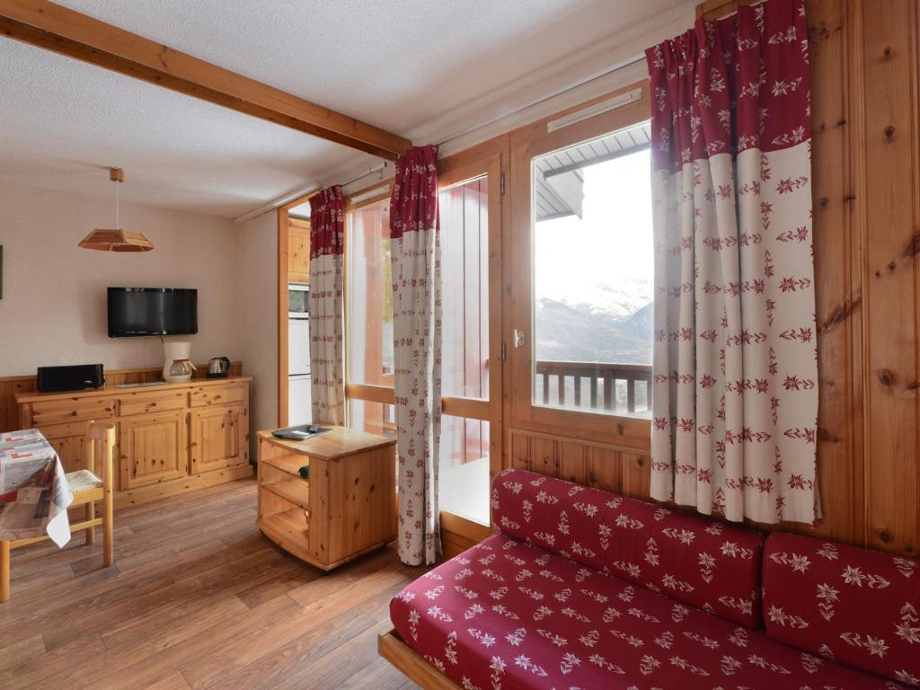 - un salon avec un canapé rouge et une fenêtre dans l'établissement Appartement Duplex Spacieux · Proche Pistes · 8 pers · Vue Mont-Blanc - FR-1-181-2488, à La Plagne Tarentaise