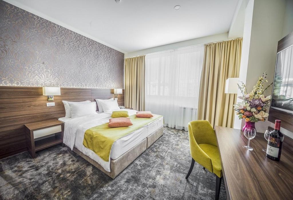 een hotelkamer met een groot bed en een bureau bij Hotel Marshal Garni in Belgrado