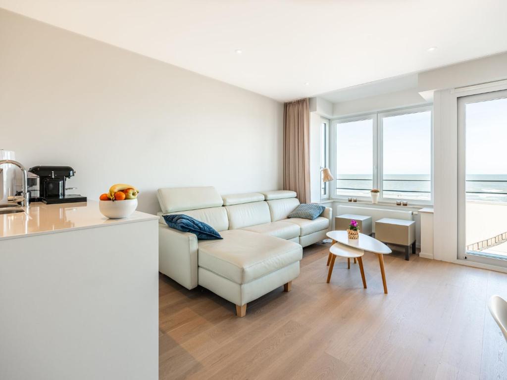 ein Wohnzimmer mit einem Sofa und einem Tisch in der Unterkunft Winoc 302 luxury family apartment on the dike in Koksijde