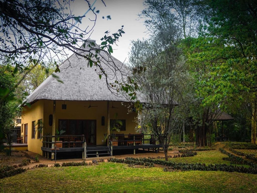a small yellow house with a grass roof at 6-person bush villa at Kruger Park entrance Phalaborwa in Phalaborwa