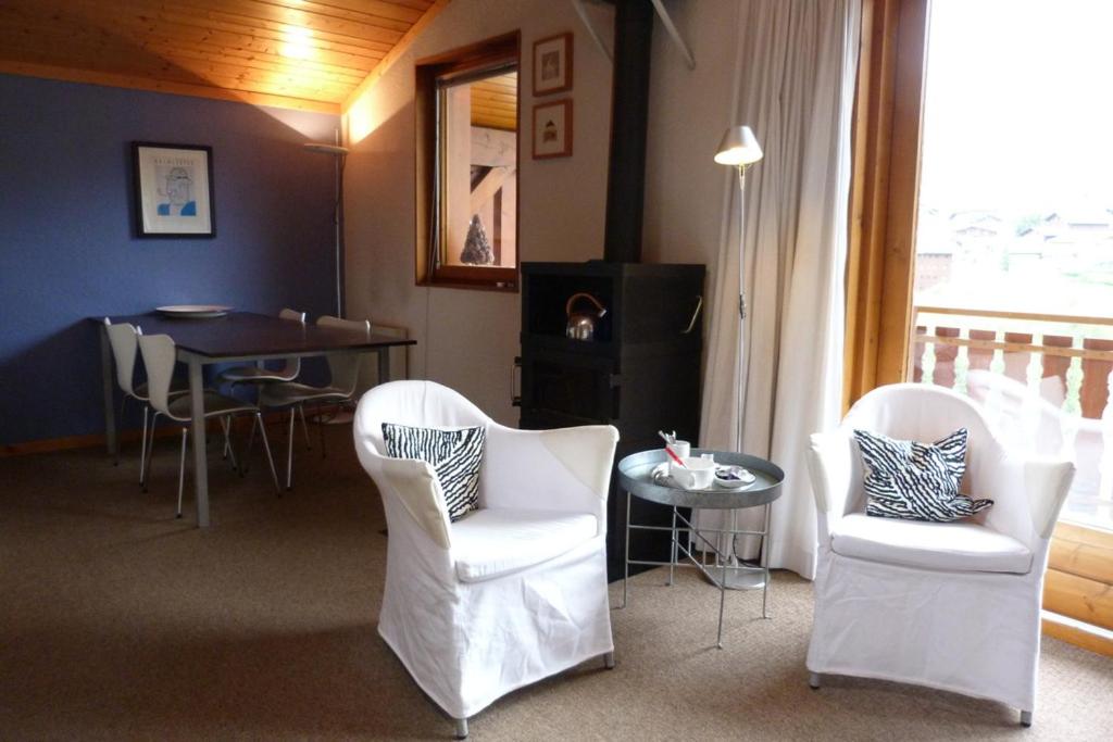 een woonkamer met witte stoelen en een tafel bij Appartement confortable, 6 personnes, 2 chambres, 1 mezzanine - BLD2 in Beaufort