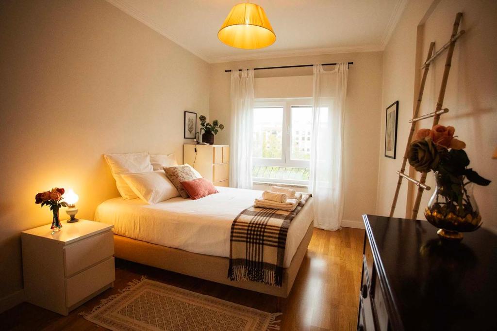 een kleine slaapkamer met een bed en een raam bij Apartamento com vista castelo in Setúbal