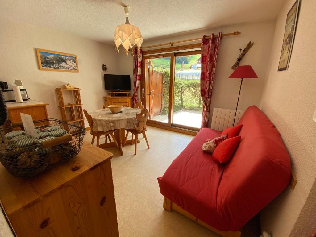 un salon avec un canapé rouge et une table dans l'établissement Appartement pied des pistes, 4 personnes, 1 chambre - MONT02, à Beaufort