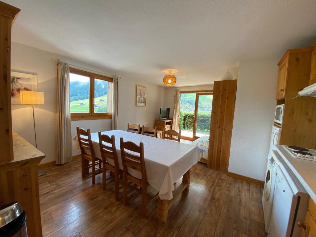 une cuisine et une salle à manger avec une table et des chaises dans l'établissement Appartement jolie vue, 6 personnes, 2 chambres - HC04, à Beaufort