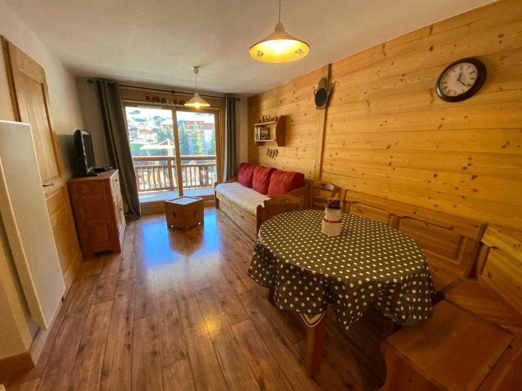 - un salon avec une table et une horloge murale dans l'établissement Appartement chaleureux, 4 personnes, 1 chambre, 1 coin montagne - MONTA11, à Beaufort