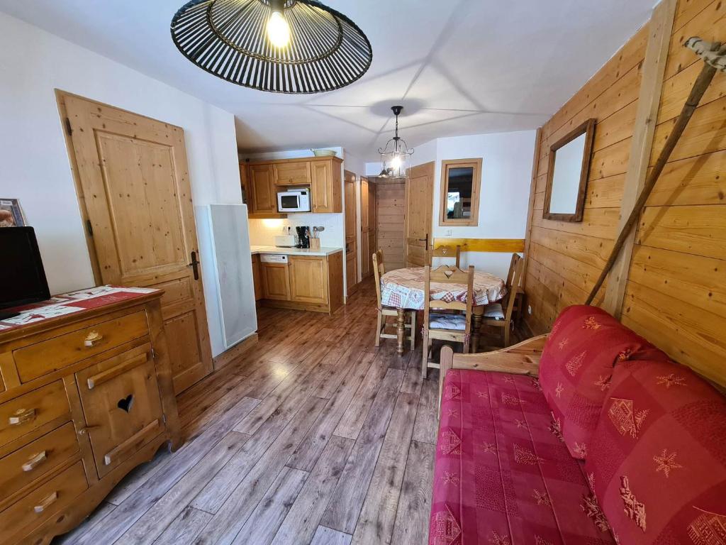 un salon avec un canapé rouge et une table dans l'établissement Appartement cosy, 4 personnes, 1 chambre, 1 coin montagne - MONTA06, à Beaufort