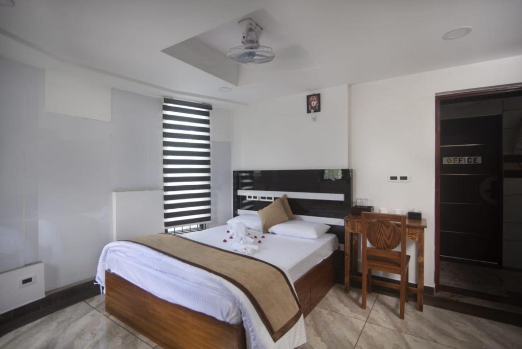 a bedroom with a bed and a desk and a chair at Magni Home in Cochin