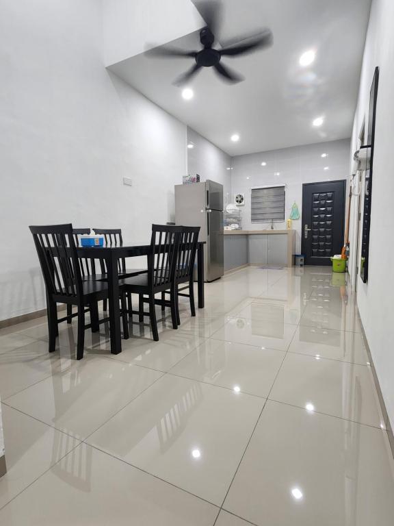 a dining room with a ceiling fan and a table and chairs at Voon 4 bedroom homestay Mersing 2 in Mersing